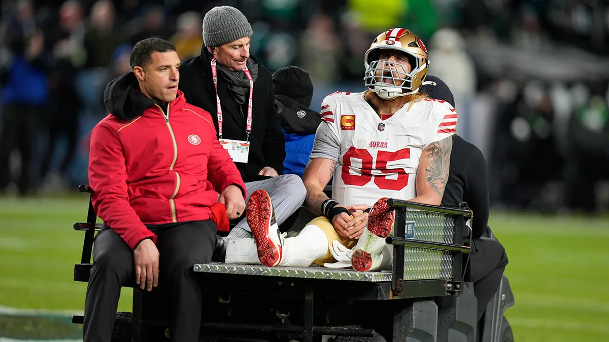 San Francisco 49ers tight end George Kittle sitting on a cart on the football field.