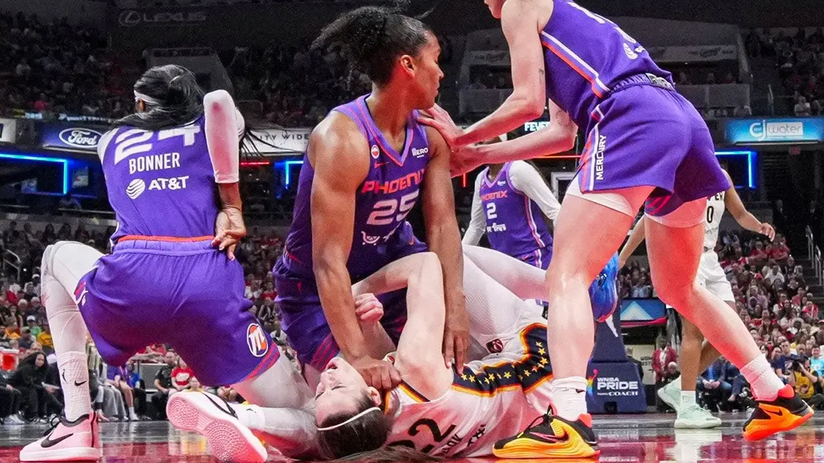 Phoenix Mercury forward Alyssa Thomas scrambling to get up over Indiana Fever guard Caitlin Clark during a basketball game