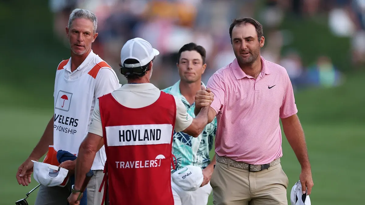 Viktor Hovland and Scottie Scheffler shaking hands with caddies on the 18th green at Travelers Championship